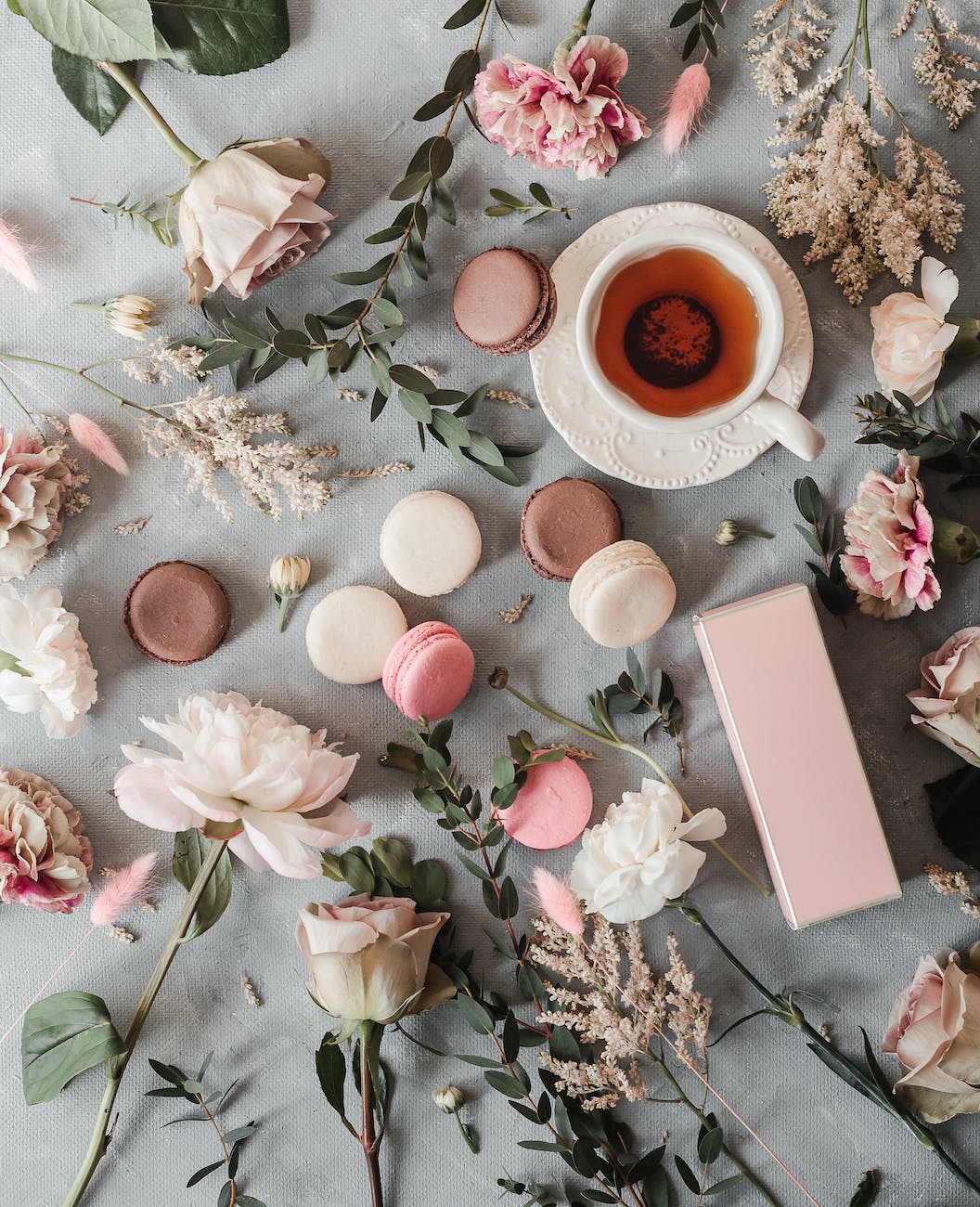 tea cup near macaroons and flowers on table